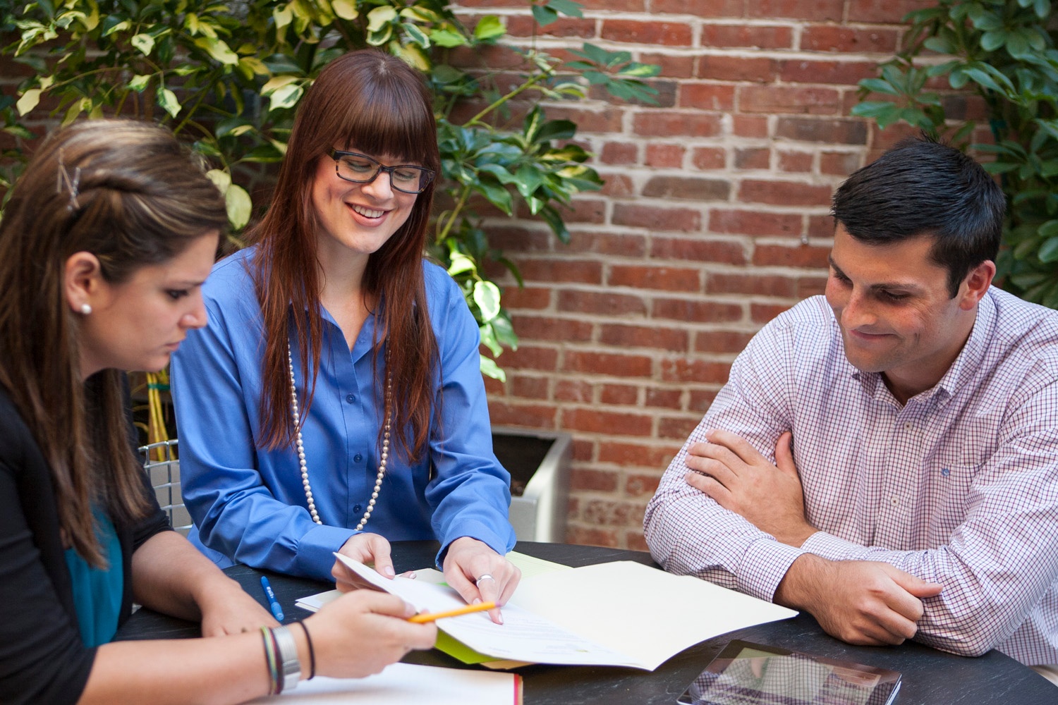 woman pointing to paper while other woman and man look on